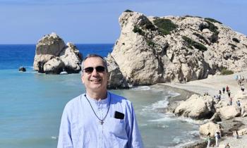 Don Enrico Casadio davanti allo Scoglio di Afrodite